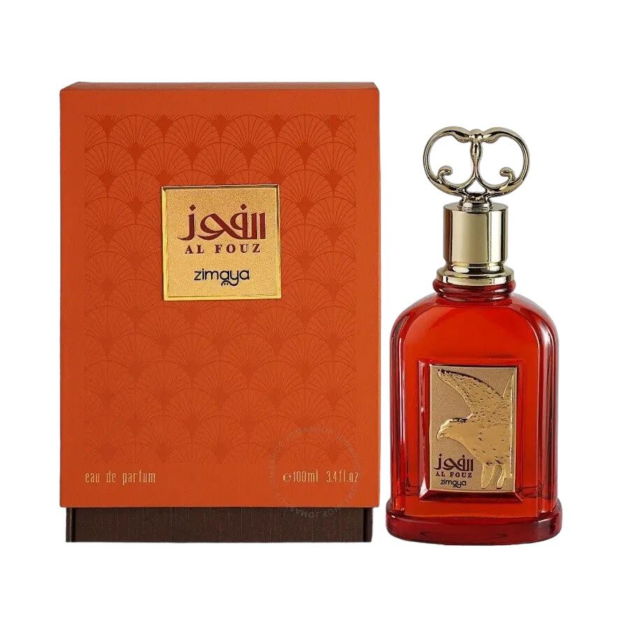 The image displays a perfume set including a bottle and its box. The box has a textured orange surface with a repeating pattern of small, stylized flowers and houses a golden nameplate at the center with Arabic script "الفوز" (Al Fouz), followed by "zimaya" in a smaller font. Below the nameplate is the label "eau de parfum" and the volume "e 100ml 3.4fl.oz." The perfume bottle is a vibrant red with a clear glass design, revealing the liquid inside.
