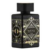 The image displays a black perfume bottle with a matte finish from Lattafa's "Oud for Glory" line, named "Bade'e Al Oud". The bottle features intricate golden designs with a central diamond-shaped label that includes the name in both Arabic and English script, framed by geometric patterns. The design conveys a sense of luxury and traditional Arabic aesthetic, commonly associated with rich and deep oud scents.