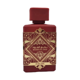 This image shows a deep burgundy perfume bottle with the name "BADEE AL OUD SUBLIME" from the brand Lattafa. The bottle has a matte finish with a matching square cap. It features a luxurious gold geometric pattern with traditional motifs, and the name is written in both Arabic and English. The word "SUBLIME" is displayed on a gold banner at the base. The design conveys a sense of rich heritage and sophistication.