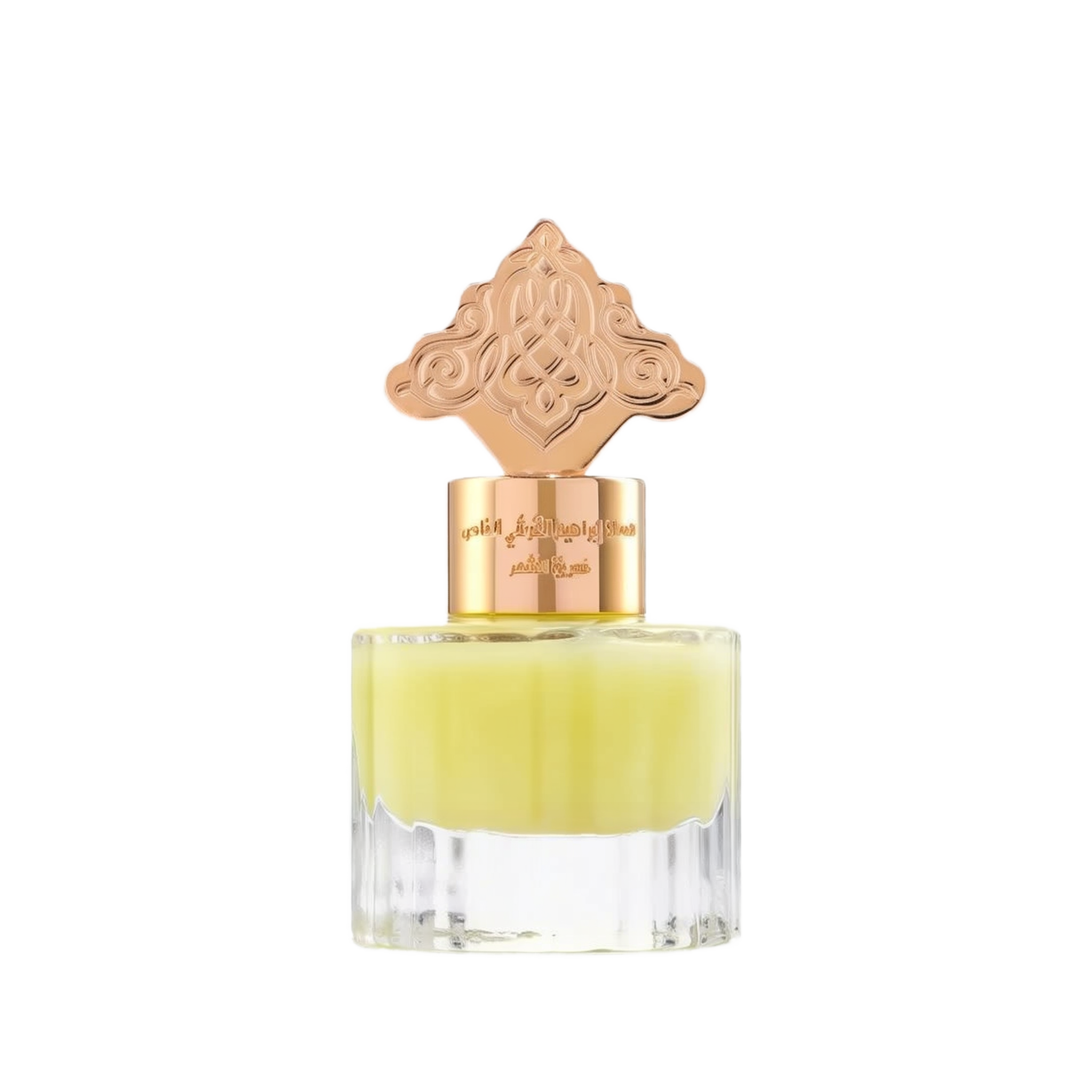 The image depicts a transparent perfume bottle with a yellow-colored liquid. The bottle is topped with a gold cap that has an ornate design, which may draw inspiration from Middle Eastern or Islamic art. The neck of the bottle features gold lettering in Arabic, likely indicating the name of the fragrance or the brand. The cap and the color of the liquid give the product a luxurious and exotic appearance, suggesting that it may be a cardamom-scented musk designed for use on hair.