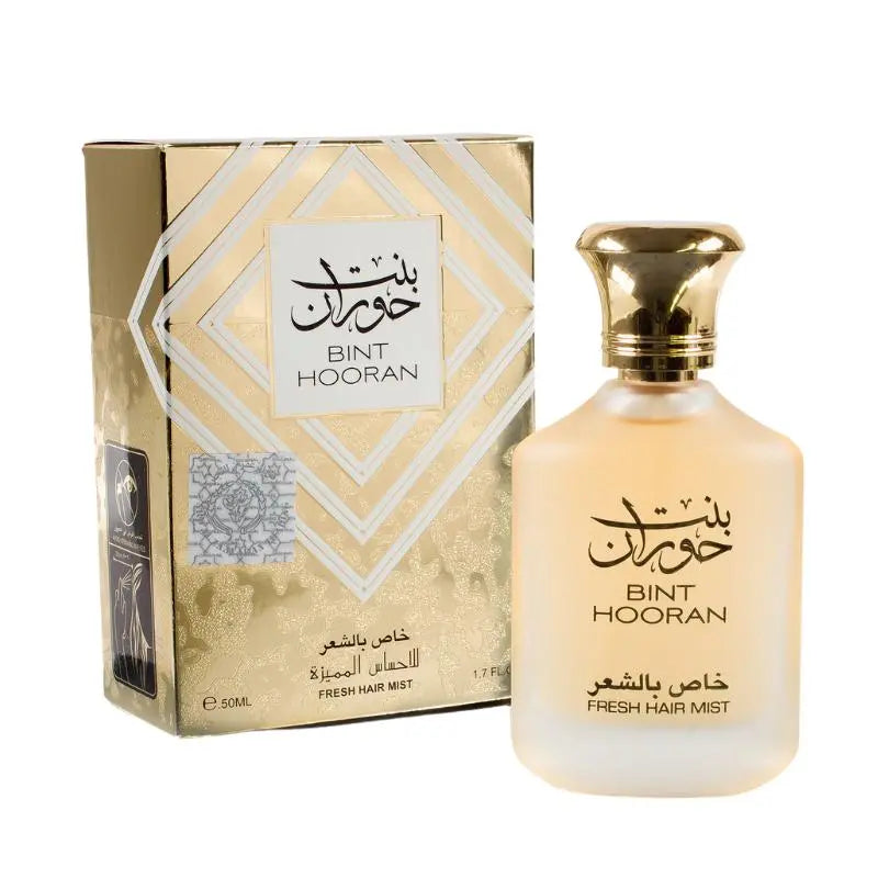 The image shows a fragrance product consisting of a bottle and its corresponding box. It features the label "BINT HOORAN" in both English and Arabic calligraphy. Below the name, the text "FRESH HAIR MIST." The box has a gold metallic finish with geometric white and gold patterns framing a white label with the name "BINT HOORAN." Additional details on the box label include "FRESH HAIR MIST" and the volume "50ML / 1.7 FL.OZ."