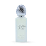  The image features a bottle of hair mist with a pastel-colored body, likely a frosted glass with a light blue tint. The cap is metallic silver with a ribbed texture, resembling a polished metal. On the bottle, there is Arabic calligraphy above the English words "Pure Musk." Below this, in a smaller font, the text "FRESH HAIR MIST" is visible. 