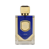 The image features a bottle of Liam Blue Shine perfume by Lattafa. The bottle has a clear, rectangular glass base with a blue color gradient at the top half. It features a prominent gold label with a textured border and the name "Liam" in stylized font in the center. Below the label, the word "Lattafa" is printed in small, simple white letters. The cap of the bottle is a smooth, metallic gold color with a faceted design, giving it a luxurious and elegant appearance.