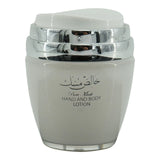 The image features a jar of "Pure Musk" hand and body lotion. The jar is a light gray color with a silver and transparent lid. On the front of the jar, there's a label with Arabic calligraphy at the top and the English words "Pure Musk HAND AND BODY LOTION" printed below. The jar's design is simple yet elegant, with the shiny silver accents of the lid adding a touch of sophistication.