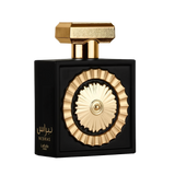 The image features a sophisticated perfume bottle with a black rectangular body and a distinctive golden circular motif in the center, resembling a sun or wheel design. The bottle has a textured gold cap with geometric shapes. Arabic script on the bottom
