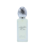 The image features a bottle of hair mist with a pastel-colored body, likely a frosted glass with a light blue tint. The cap is metallic silver with a ribbed texture, resembling a polished metal. On the bottle, there is Arabic calligraphy above the English words "Pure Musk." Below this, in a smaller font, the text "FRESH HAIR MIST" is visible.