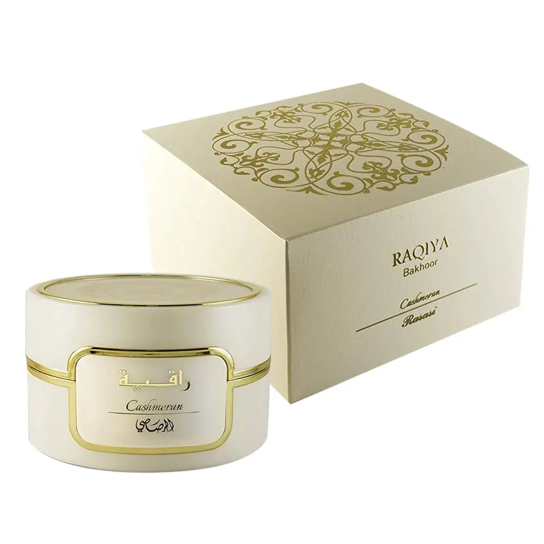 A creamy white jar with a golden rim and label sits in front of its matching box, which has a gold ornate design and the words "RAQIYA Bakhoor Cashmeran Rasasi" printed on it. This presentation suggests it is a premium bakhoor product, which are scented bricks or a blend of natural traditional ingredients, used in the Middle East to perfume the house and clothing.