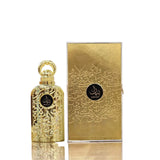 The image features a product set consisting of a perfume bottle and its packaging box. The perfume bottle is identical to the previous description, with a golden color and intricate arabesque patterns, and a black label with the word "BAYAAN" in stylized white Arabic script. Next to the bottle stands its box, which is a golden color with a texture that gives it a metallic sheen. It also has arabesque patterns and the "BAYAAN" branding in the same style as on the bottle.