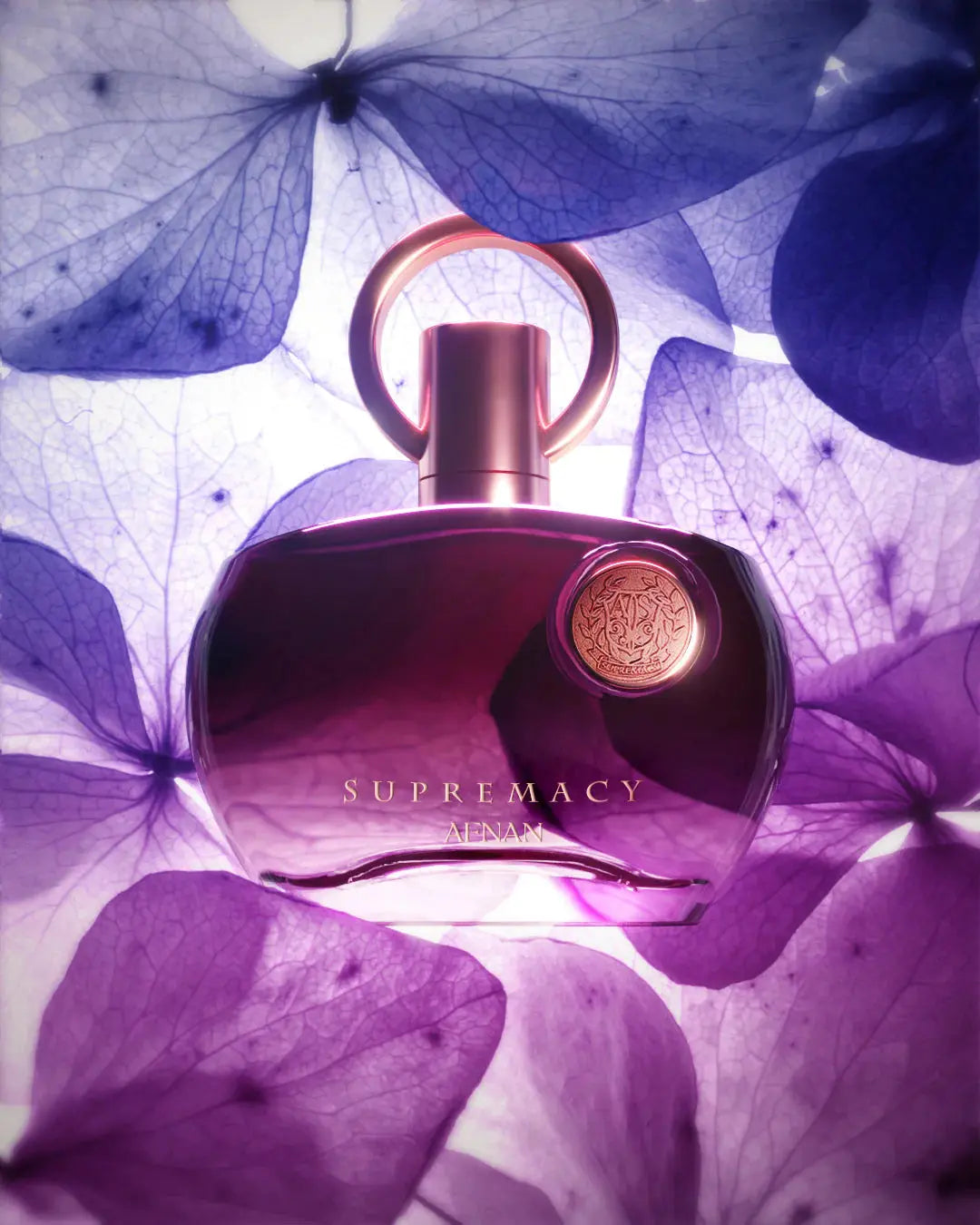 The image features an artistic presentation of a perfume bottle named "SUPREMACY" by AFNAN. The bottle is set against a backdrop of translucent purple petals that give the composition a dreamy and delicate feel. The perfume bottle, centered in the composition, has a rich, dark purple to almost black gradient color with a metallic rose gold cap and a circular loop design.  The lighting gives the bottle and the petals a luminous quality, suggesting a sense of opulence and sophistication.