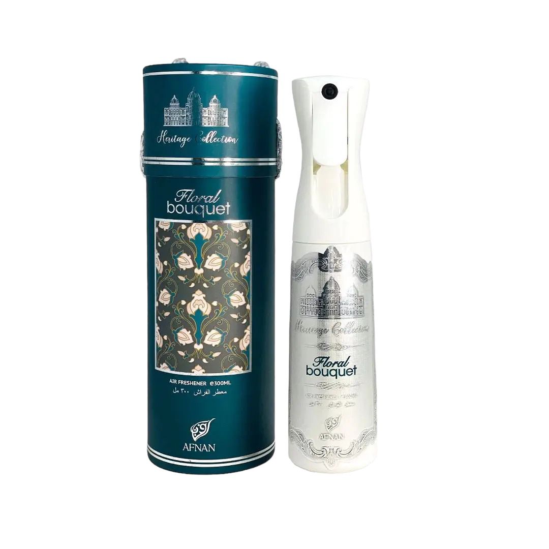 he image features an air freshener bottle and its packaging. The cylindrical container is a deep teal color with a silver cap and a decorative panel showcasing a floral pattern with rose motifs, titled "Floral Bouquet." Above the pattern, the words "Heritage Collection" are printed in silver, along with intricate architectural depictions. The same branding is visible on the white air freshener bottle, which has a nozzle for spraying and is adorned with a matching teal label with floral designs. 