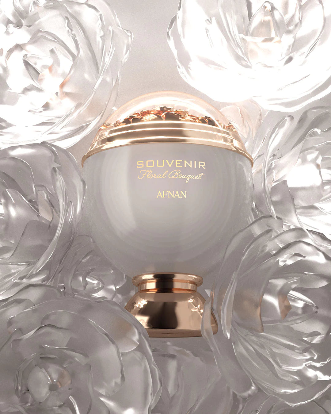 The image shows a perfume bottle with a clean and elegant design. The bottle has a spherical white body with a golden band that reads "SOUVENIR Floral Bouquet AFNAN." Above the band is a clear dome, encasing what appears to be a cluster of golden petals or flakes, giving a sense of luxury. The bottle rests on a golden pedestal base that complements the golden accents.