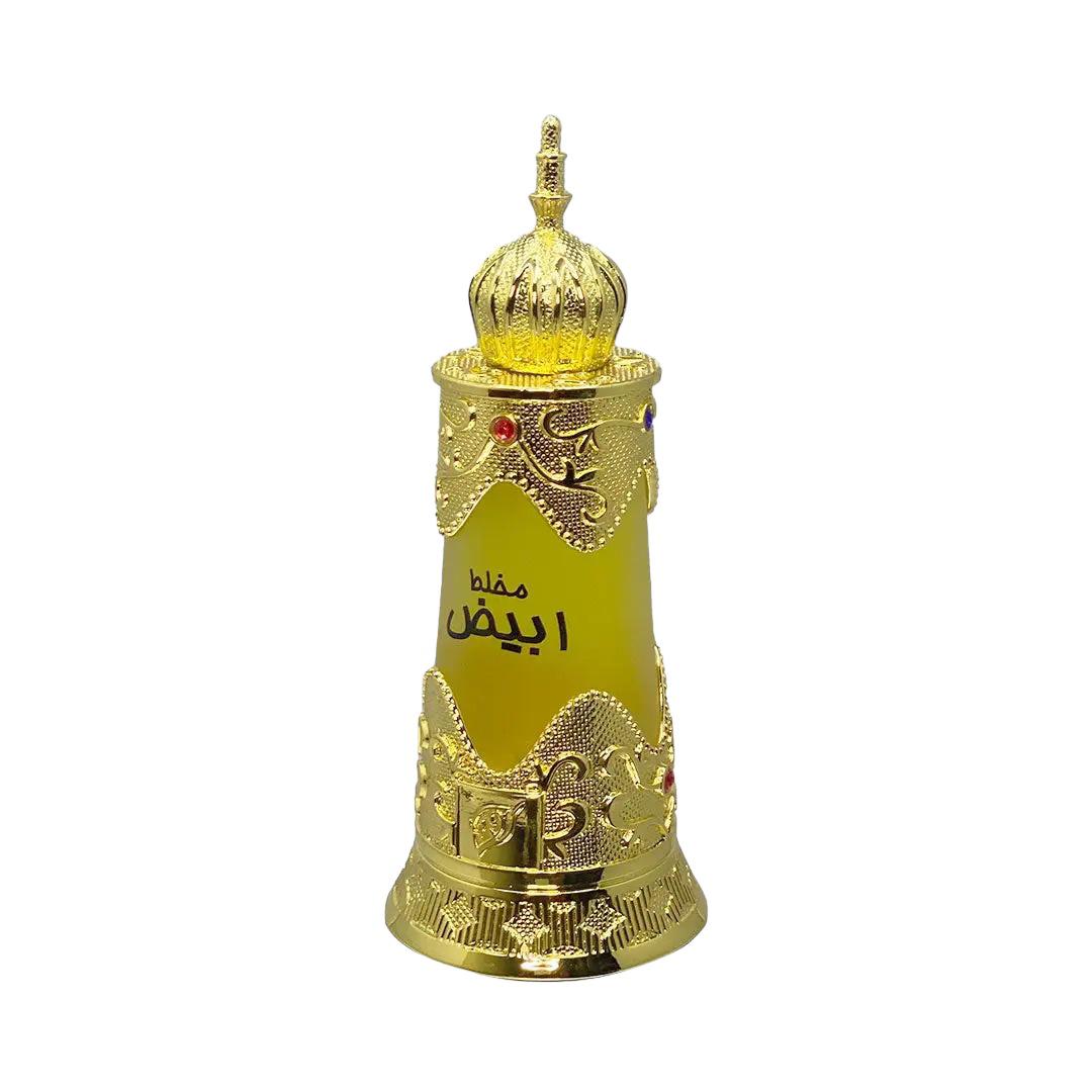 The image shows an ornate golden-yellow perfume bottle with intricate metallic gold details and embossed patterns. The body of the bottle tapers elegantly towards the base and flares out slightly at the shoulder, giving it a regal silhouette. It features Arabic calligraphy in the center, possibly indicating the name of the fragrance or the brand. Adorned with two gemstones, one red and one purple, the bottle has a luxurious and exotic appearance. 