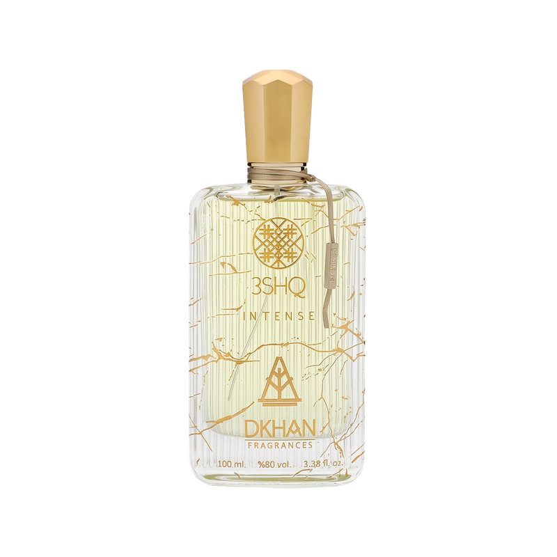 The image displays an elegant, clear glass perfume bottle adorned with artistic golden lines and splashes against a soft, off-white backdrop. The bottle is labeled "3SHQ INTENSE" in a refined font, with the "DKHAN FRAGRANCES" emblem prominently featured beneath it. A gold-colored cap sits atop the bottle, complementing the golden accents. The fragrance liquid has a light, amber tint, suggesting a sense of warmth and richness.