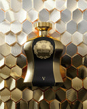 The image features an elegant black perfume bottle with a textured surface and gold accents, including a gold cap. The front of the bottle showcases an ornate gold crest with the word "HIGHNESS" and a crown symbol, as well as the Roman numeral "V". The bottle is set against a background that resembles a honeycomb pattern in reflective gold and silver tones, which complements the bottle's luxurious appearance.