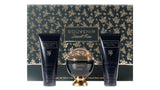 The image features a luxurious bath and body set from the "SOUVENIR Desert Rose" collection by Afnan. The set includes a spherical golden perfume bottle with a clear dome top, flanked by two navy blue tubes—one labeled as "ENERGIZING SHOWER GEL" and the other as "LUSTEROUS NATURAL BODY LOTION". Each product has gold lettering and rose accents. The background and base of the set feature an elegant pattern of gold roses on a dark, forest green backdrop.