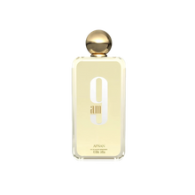 The image depicts a minimalist-designed perfume bottle with a golden cap. The bottle is transparent, revealing a pale yellow liquid inside, suggesting the perfume color. On the bottle's front, in large, white, modern font is "9 am," with the lowercase "am" nestled within the number 9. Below this, in smaller uppercase letters, reads "AFNAN."  The bottle is centered against a white background, which emphasizes the simplicity and elegance of the design.