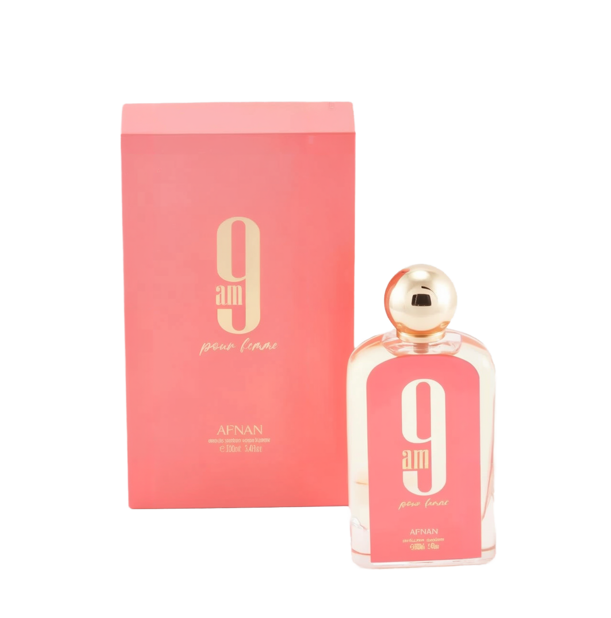 The image displays a rectangular glass perfume bottle and its corresponding box. The bottle is clear with a pink hue and has a white oval label with a large "9" and "am" in black font, with "pour femme" in smaller script below it. The cap is a polished gold sphere. At the bottom of the bottle, "AFNAN" is printed, along with "100ml | 3.4fl.oz". The box is a matching pink color with the same "9 am pour femme" branding and additional text "eau de parfum vaporisateur". 