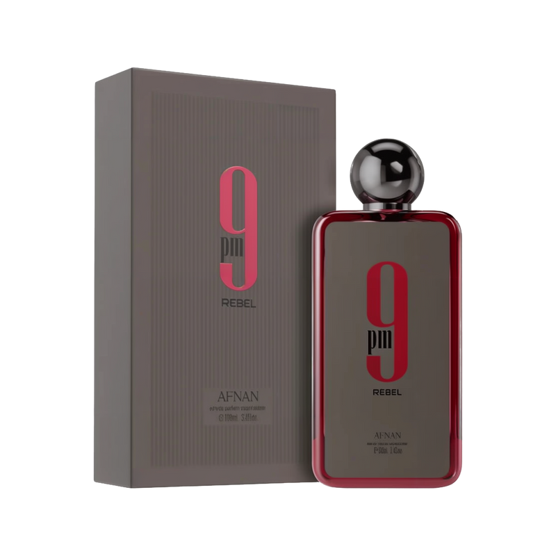 A rectangular fragrance bottle from Afnan labeled “9 pm Rebel,” featuring a metallic spherical cap and a glossy red border around a dark gray front, positioned beside a matching gray box emblazoned with pink and black branding.