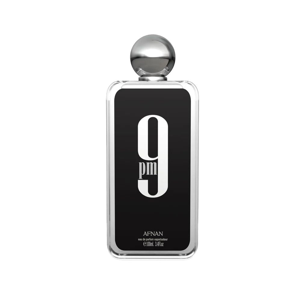 The image shows a sophisticated perfume bottle with a minimalist design. The bottle is rectangular with rounded edges and appears to be made of clear glass.  Featured prominently on the label is the number "9" above the lowercase letters "am," suggesting the product's name as "9 am." Below this, in smaller uppercase letters, is the brand "AFNAN." At the bottom of the label, there's text indicating the volume as "100ml, 3.4fl.oz." The cap of the bottle is spherical and gold-colored.