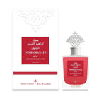 The image shows a set of a perfume product, including the packaging and the bottle. The product is "POMEGRANATE MUSK" by Ibraheem Al Qurashi. The packaging is predominantly white with a red label in the center that matches the red label on the clear glass perfume bottle. The bottle has a clear, ornate design with a silver-colored, intricately designed cap. The packaging and bottle feature Arabic calligraphy and English text, indicating the fragrance's name and the brand, described as special.