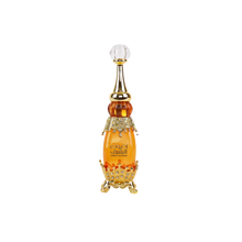 Elegant bottle of Adwaa Al Sharq with jewel-studded gold base and crystal-clear pointed stopper.