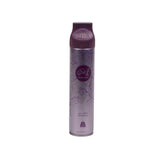 The image shows a tall, slender aerosol air freshener can in a deep purple hue with a ribbed cap. It's adorned with lighter purple swirls and floral patterns, creating an elegant appearance. The label features an ornate frame with Arabic calligraphy and the English text "Tamaly Maak," indicating the fragrance. The product is set against a plain, light background to emphasize its design and color.