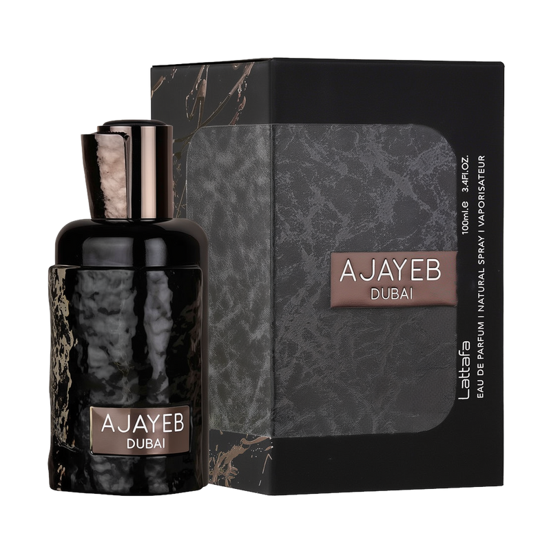 A sleek black and gray box of "Ajayeb Dubai" Eau de Parfum by Lattafa, featuring a textured design and the product name in white and bronze text on the front. The box is placed next to a matching perfume bottle with a glossy, hammered black finish.