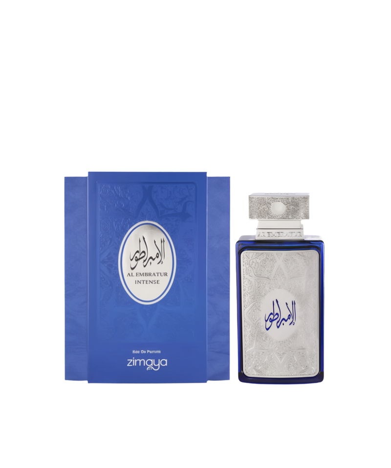 A bottle and packaging of Al Embratur Intense Eau De Parfum by Zimaya. The perfume bottle is deep blue with an ornate silver front panel and matching silver cap, both featuring intricate embossed patterns. The name "Al Embratur Intense" is displayed in elegant Arabic and English script. The box echoes the bottle’s design with a similar blue and silver color scheme and embossed detailing, emphasizing a luxurious and regal aesthetic.