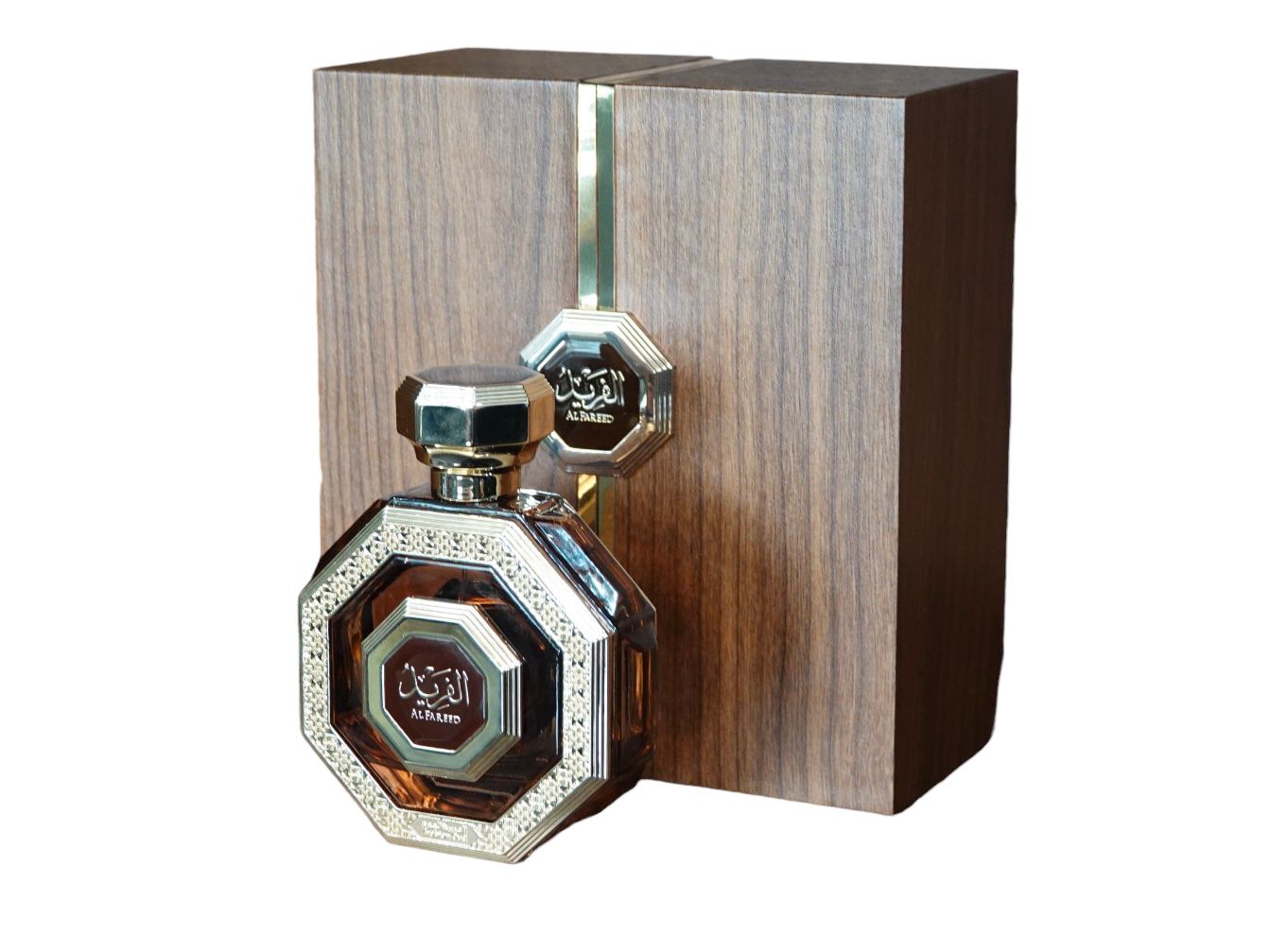 An intricately designed octagonal perfume bottle with a reflective silver cap, placed next to a wooden textured box that has a metallic strip running vertically down the center. Both the bottle and the box bear the label "Al Fareed" in Arabic calligraphy, suggesting it's a luxurious Arabian oud fragrance product. The overall presentation is rich and traditional.