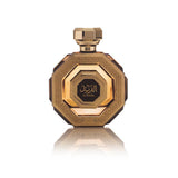 The image is of a perfume bottle displayed against a white background. The bottle has an octagonal shape with a faceted design, giving it the appearance of a cut gem. It is colored in rich gold tones with intricate patterns and textures on its surface that suggest a sense of luxury and opulence.  The cap of the bottle matches the golden design and has a geometric shape consistent with the overall aesthetic.