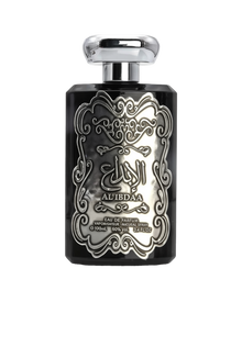 The image features a black perfume bottle with a detailed silver embossed design on the front. The central design includes Arabic calligraphy that reads 'AL IBDAA', likely the name of the fragrance. Below the calligraphy, in smaller English text, it states 'EAU DE PARFUM', 'VAPORISATEUR NATURAL SPRAY', '100ml', '80% VOL', and '3.4 FL.OZ', which describe the product type, dispensing method, volume, alcohol content, and fluid ounces, respectively. 