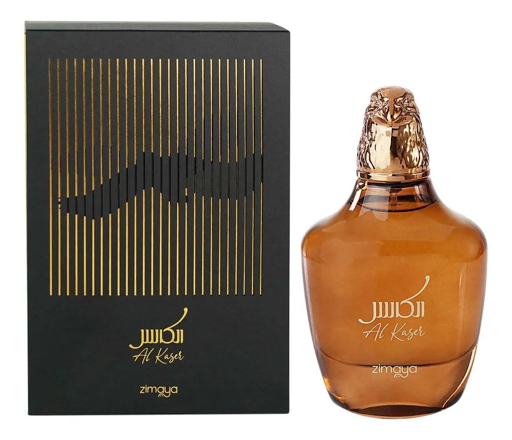 The image features the "Al Kaser" fragrance by Zimaya, presented with its packaging and the perfume bottle. The packaging is a sophisticated black box adorned with vertical gold lines creating a partial, stylized outline of a falcon. Below the falcon design, in elegant gold script, is the name "Al Kaser" along with the brand "zimaya". Next to the box is the fragrance bottle, which has a robust, rounded shape with a transparent brown hue, evoking a sense of warmth and richness. 