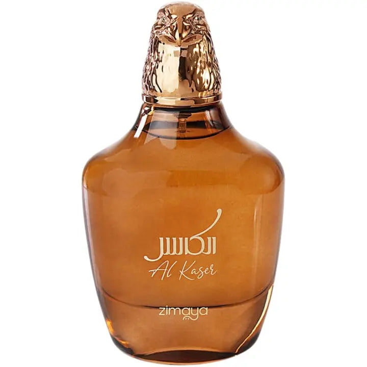  The image displays a perfume bottle of "Al Kaser" by Zimaya. The bottle has a broad, rounded base and tapers slightly toward the top. It is made of a translucent brown glass that gives it a warm, amber appearance. The cap is a detailed golden sculpture of a falcon's head, symbolizing luxury and possibly the fragrance's inspiration. The name "Al Kaser" is elegantly inscribed on the bottle in white cursive script.