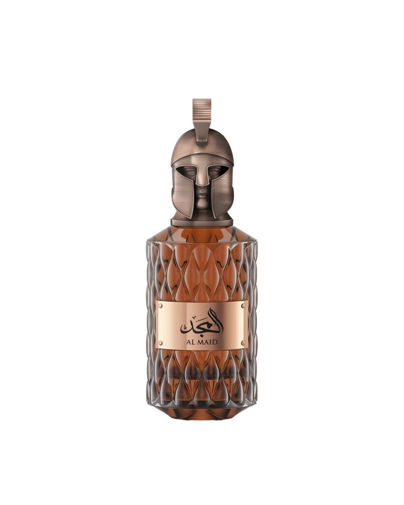 A product shot of Le Falcone Niche Collection’s “Al Majd” perfume bottle against a white background: a tall, amber-colored glass vessel with a diamond-cut texture and a polished bronze plaque displaying Arabic calligraphy above the words “Al Majd.” It’s crowned by an ornate bronze cap sculpted into a stylized warrior’s helmet with a crest-style loop at the top, conveying a sense of luxury and strength.