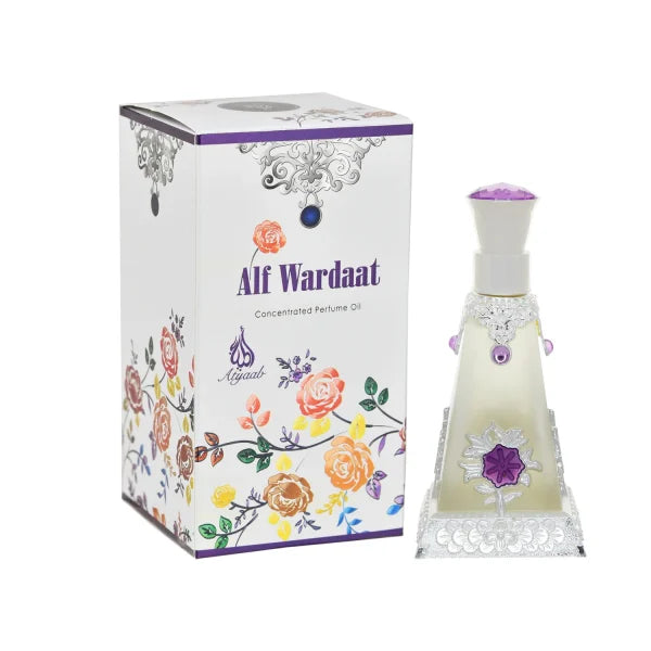 A pyramid-shaped perfume bottle with intricate silver detailing and purple accents, featuring a purple flower design on the front, displayed next to a white box adorned with colorful floral patterns and the text 'Alf Wardaat Concentrated Perfume Oil' in purple letters.