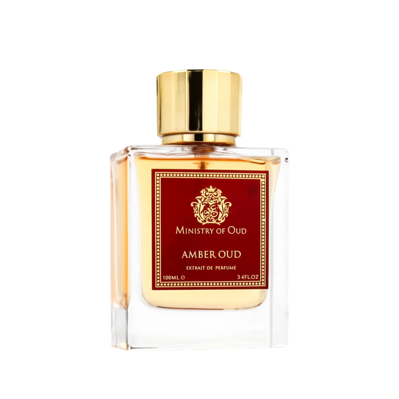 Image of 'Amber Oud' Extrait de Parfum by Ministry of Oud, Paris Corner. The 100ml perfume bottle is made of clear glass with a rich amber-colored liquid inside. It has a square design, a prominent gold cap, and a red label with intricate gold detailing and text, giving it a classic and luxurious appearance.