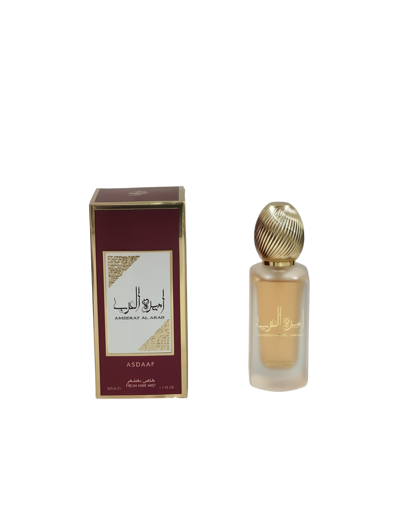  The image displays a maroon and gold packaging box alongside a frosted glass perfume bottle with a gold ribbed cap. The box has the name "AMEERAT AL ARAB" in white against a gold background on both the English and Arabic scripts, with the brand "ASDAAF" below it. Below on the box, it states "50ML / FRESH HAIR MIST / 1.7 FL.OZ."