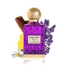The image depicts a vibrant purple glass perfume bottle with a textured gold cap, labeled "Amethyst Khozam" in both Arabic and English script, suggesting the fragrance's name by the brand Ibraheem Al Qurashi. The bottle has a faceted design, reminiscent of cut amethyst gemstones. Accompanying the bottle are elements that hint at the scent's composition: a bundle of cinnamon sticks to the left, a slice of lemon in front, a white orchid flower at the bottom, and sprigs of lavender to the right.