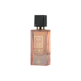 Ana Abiyedh Coral perfume in elegant peach bottle with gold detailing and sleek black cap.