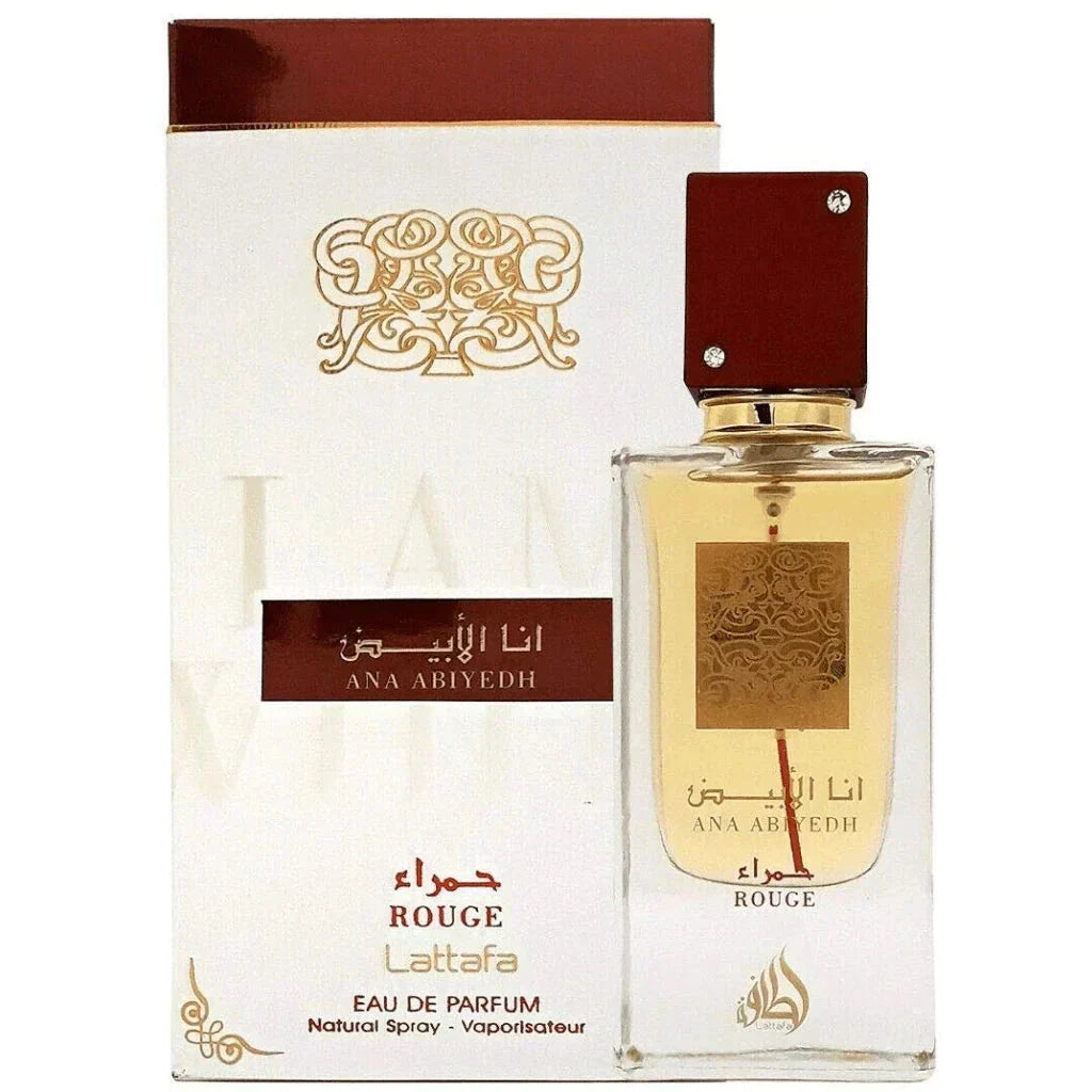 Image featuring a clear glass perfume bottle with a gold label and red cap, in front of its white and brown packaging box. The bottle's gold label has arabesque designs and Arabic calligraphy reading '??? ????' (Ana Abiyedh) and 'ROUGE' in red, with a red line that continues down from the label. The cap is adorned with two crystals. The box has a similar design, with the brand name 'Lattafa' and 'Eau de Parfum' written in brown, along with 'Natural Spray - Vaporisateur'.