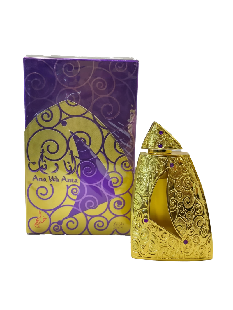 The image shows a product called "Ana Wa Anta" by Khadlaj, which is a concentrated perfume oil. The perfume is housed in a uniquely designed gold bottle adorned with intricate swirling patterns and purple gems. The bottle has a triangular cap and a crescent-shaped window revealing the golden liquid inside. The packaging box features a matching gold and purple design with swirling patterns and the product name "Ana Wa Anta" displayed in both English and Arabic.