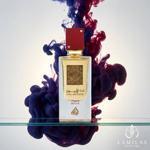 Close-up of Ana Abiyedh Rouge perfume, featuring a red cap and gold label, surrounded by dramatic purple ink clouds.
