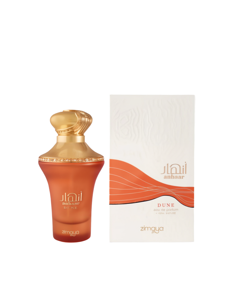A bottle and packaging of Anhaar Dune Eau De Parfum by Zimaya. The bottle features a warm amber-orange frosted glass with a curvy silhouette, topped with an ornate golden cap and trim. The front displays the name "Anhaar Dune" and the Zimaya logo in gold lettering. The accompanying box is white with an embossed texture and a flowing orange wave design, reflecting a desert-inspired, earthy theme.