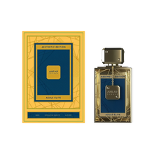 A rectangular gold and blue perfume bottle with a matching box. The box displays geometric line patterns and the words "Aesthetic Edition" and "Azule Elite." The bottle features a blue label framed by gold lines, a gold-toned cap, and a small decorative chain hanging from the neck.