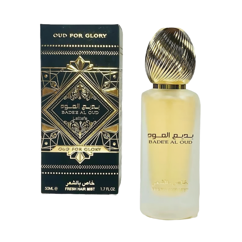 The image features a frosted glass perfume bottle with a golden ribbed cap and a black and gold packaging box. The box has an intricate geometric and arabesque design in black and gold, with the name "OUD FOR GLORY" and "BADEE AL OUD" prominently displayed, alongside the brand "Lattafa." The box also specifies "50ML / FRESH HAIR MIST / 1.7 FL.OZ." 