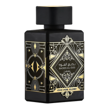  The image displays a black perfume bottle with a matte finish from Lattafa's "Oud for Glory" line, named "Bade'e Al Oud". The bottle features intricate golden designs with a central diamond-shaped label that includes the name in both Arabic and English script, framed by geometric patterns. The design conveys a sense of luxury and traditional Arabic aesthetic, commonly associated with rich and deep oud scents.