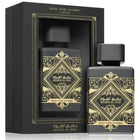 The image features a black perfume bottle with a matte finish, alongside its packaging. The bottle is labeled "BADE'E AL OUD" and "OUD FOR GLORY" by Lattafa. Both the bottle and the box bear intricate golden geometric and arabesque designs with the name written in both Arabic and English. The box has an open window through which the bottle is visible, framed by a golden border that matches the aesthetic of the bottle's design.