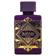 Purple Bade’e Al Oud Amethyst perfume bottle with gold geometric label on white background.
