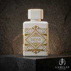 Lattafa Bade'e Al Oud Honor and Glory white perfume bottle featuring an intricate gold geometric design, displayed on black stone.