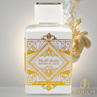 White Lattafa Bade'e Al Oud Honor & Glory perfume bottle featuring a gold Art Deco label, set against an amber and white scent cloud.
